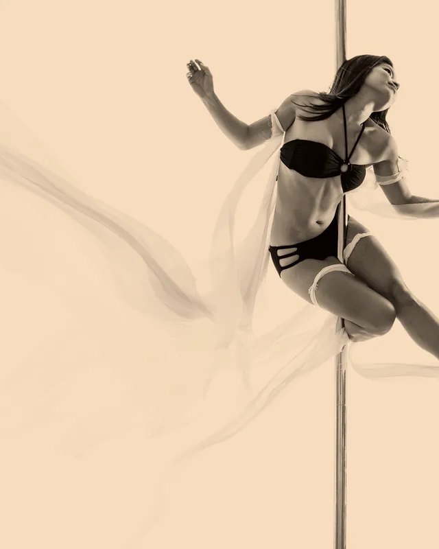 Bailarina em abertura de pernas suspensa na barra, ilustrando a aula de flexibilidade